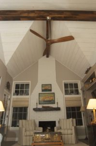 Wide view of living room featuring barnwood mantle and beams.